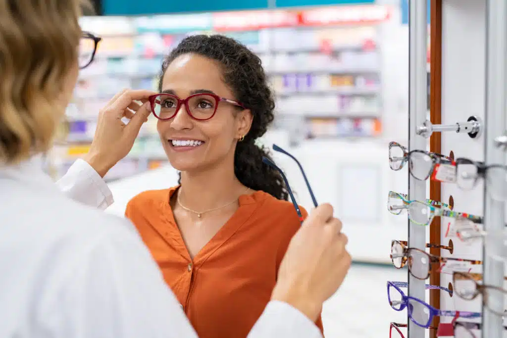 A woman getting fitted for eye glasses with an eye doctor.