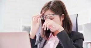 Asian woman worker feel tired and rubbing eyes